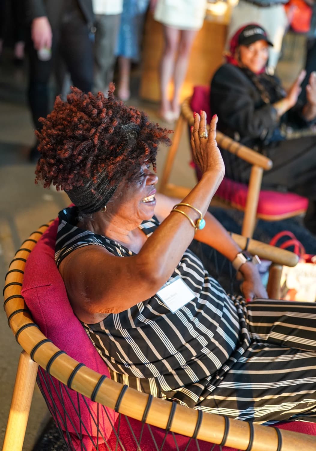 A guest laughing with her hand raised