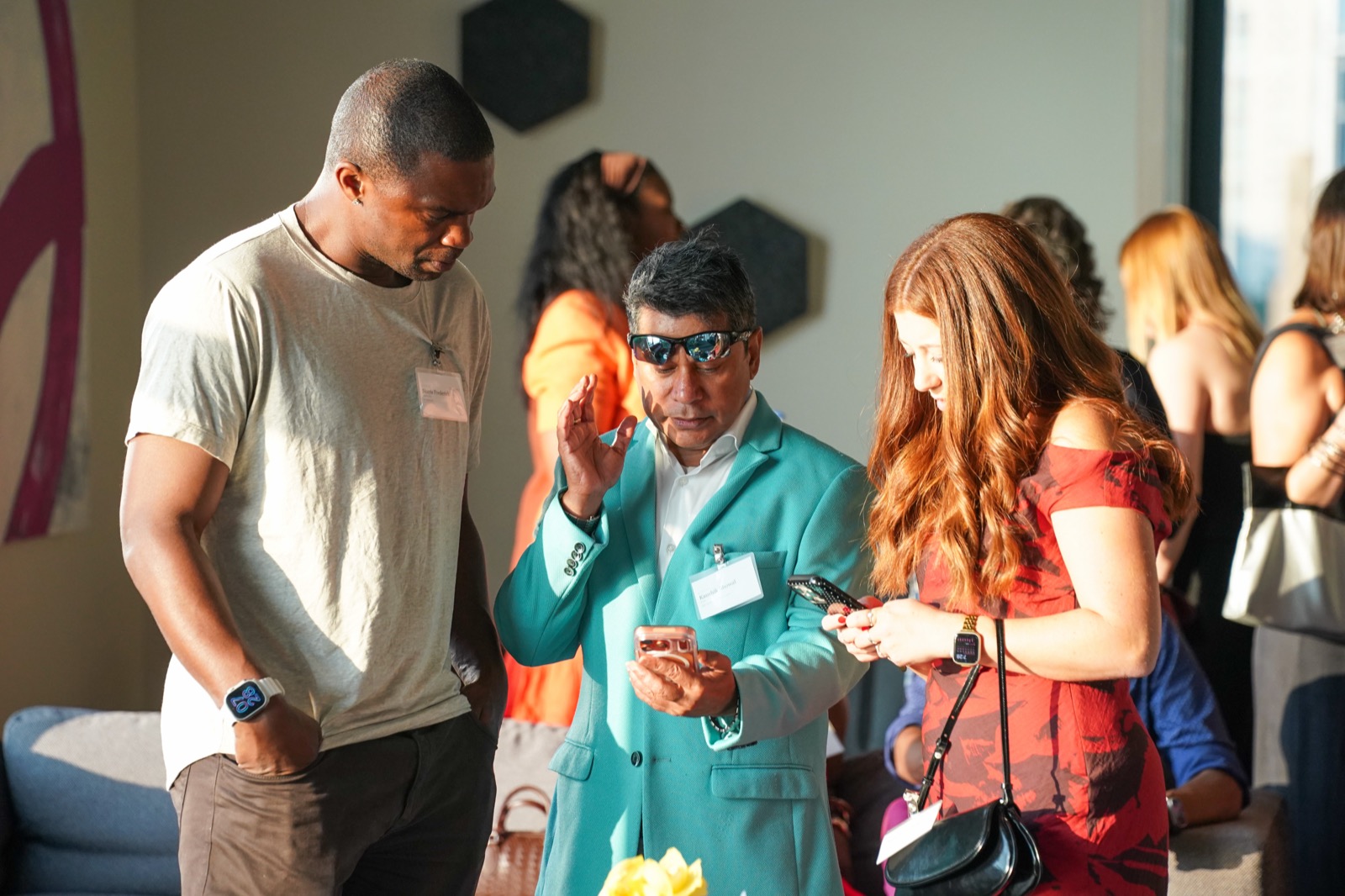 Guests leaning in together over a phone at the Vantage launch party