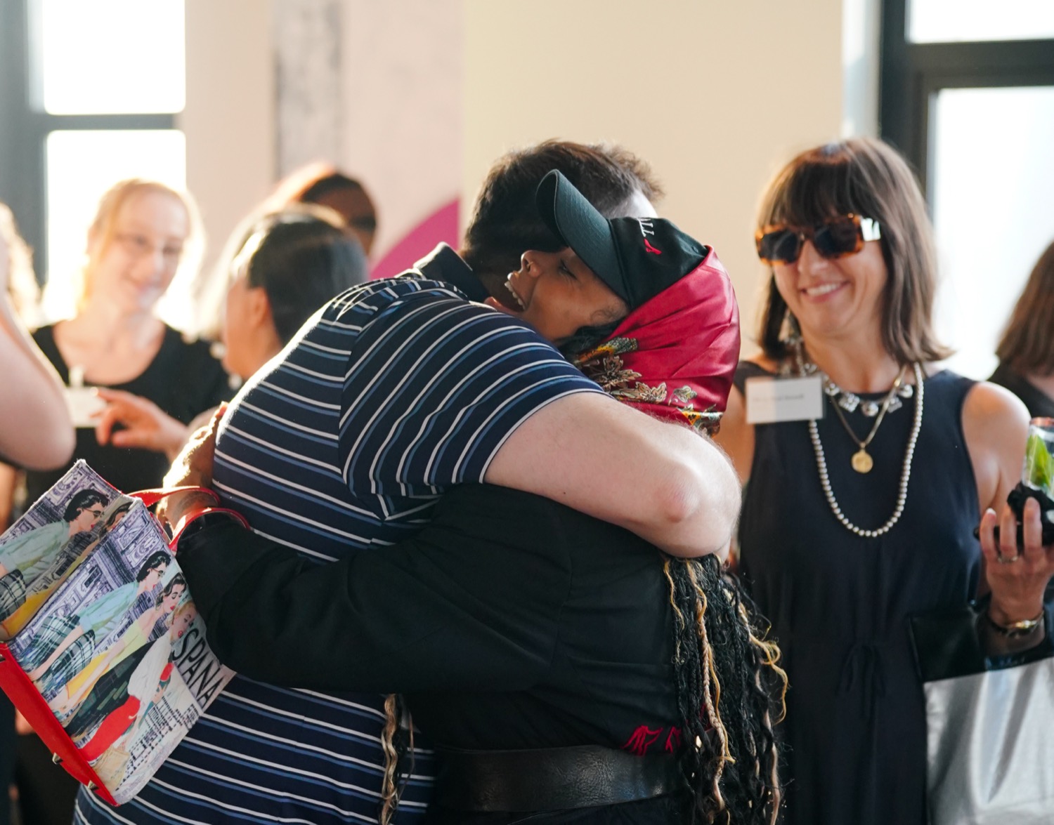 Two guests greeting each other at the Vantage launch party on the 25th floor at Harbor Steps